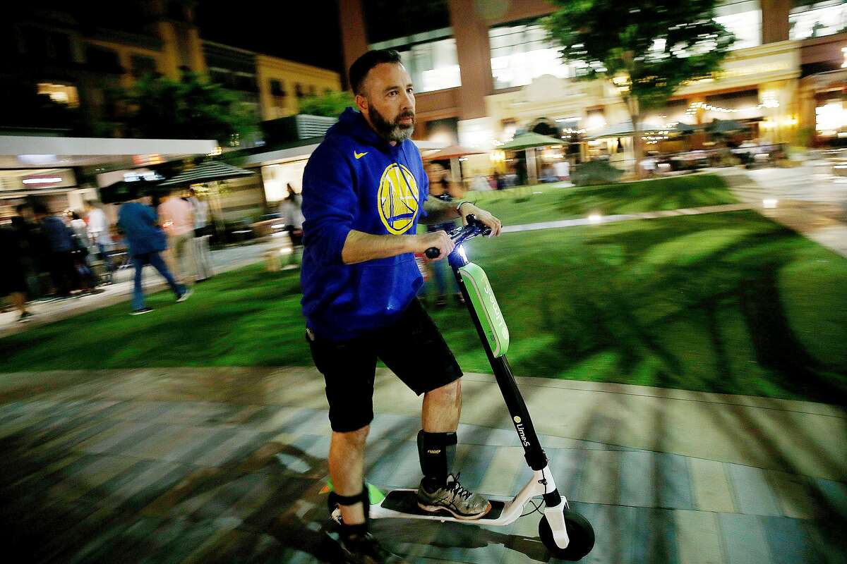 David Padover, who is a Juicer for Lime-S, rides a scooter he collected at Santana Row, while scooter hunting in San Jose, California on July16, 2018. (Josie Lepe/Special to the Chronicle)