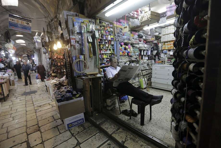   A trader is waiting for his clients on July 11 in the Muslim quarter of the Old City of Jerusalem. Palestinians are skeptical about a half-billion-dollar Israeli plan to develop East Jerusalem. Photo: Mahmoud Illean / Associated Press 