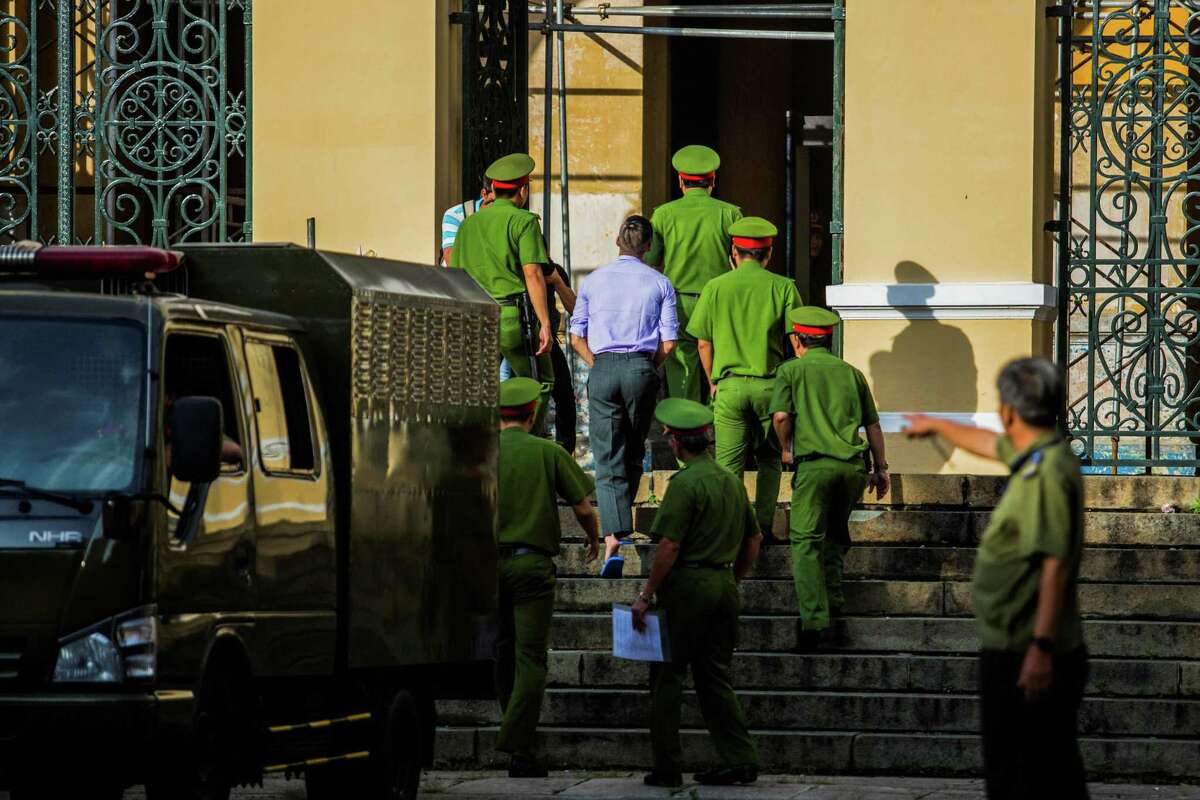 American-Vietnamese citizen William Nguyen is escorted by policemen to a courtroom for his trial in Ho Chi Minh City on July 20, 2018. He was convicted and released. AFP/Getty Images
