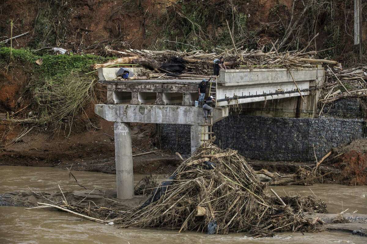 FILE -- Hurricane Maria destroyed this bridge over the Vivi River near Utuado, Puerto Rico, forcing people on Sept. 27, 2017, to climb down using ladders and a pile of debris and then cross the river on foot. The Federal Emergency Management Agency?’s plans for a crisis in Puerto Rico were based on a focused disaster like a tsunami, not a major hurricane devastating the whole island. The agency vastly underestimated how much food and fresh water it would need, and how hard it would be to get additional supplies to the island. Those and other shortcomings are detailed in a draft FEMA report assessing the agency?’s response to the 2017 storm season, when three major hurricanes slammed the U.S. in quick succession, leaving FEMA struggling to deliver food and water quickly to storm victims in Puerto Rico.(Kirsten Luce/The New York Times)