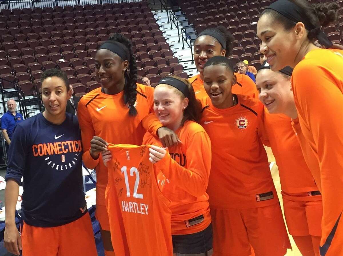 Caroline Hartley from Scarborough, Maine poses with a photo with members of the Connecticut Sun on Friday at Mohegan Sun Arena.