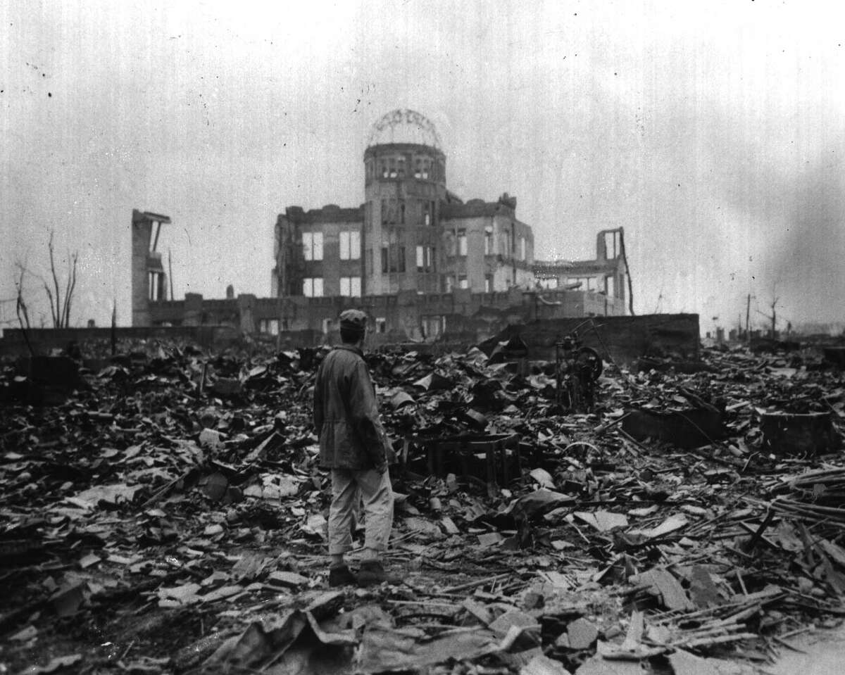 HIROSHIMA JAPAN--An allied war correspondent stands in the ruble that was Hiroshima, one of Japan's key industrial cities, looking at the ruins of a motion picture House. The city was hit with the first Atomic Bomb droped from the flying B-29 superfortress Enola Gay. 9/8/1945. -4- Mcbride.