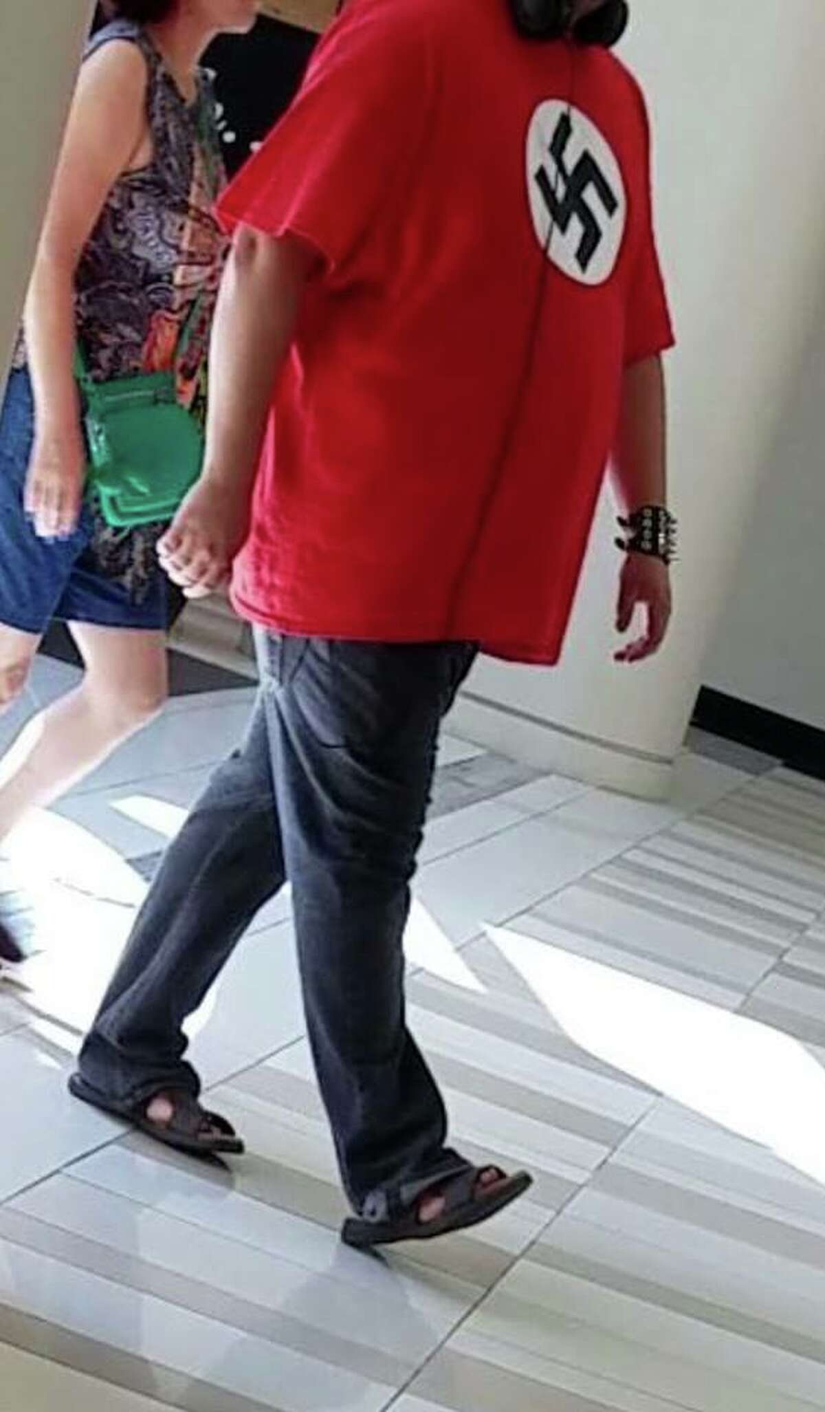 A photo taken by a patron at Crossgates Mall Friday, July 20, 2018 shows an unidentified man wearing a shirt that looks like the Nazi flag. (Provided)