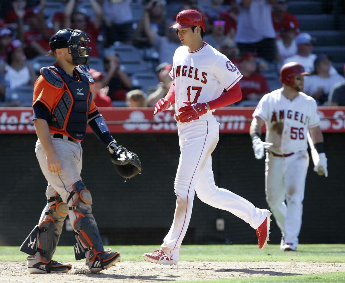 Los Angeles Angels designated hitter Shohei Ohtani (17), of Japan, scores without a throw to Houston Astros catcher Tim Federowicz, left, on a two-run single by David Fletcher during the seventh inning of a baseball game in Anaheim, Calif., Sunday.