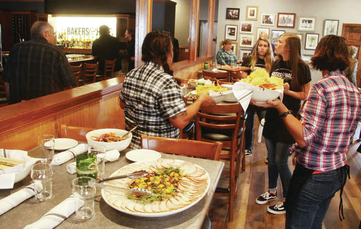 Servers put out food for guests at a ribbon-cutting ceremony Thursday at the new Godfrey Restaurant Bakers & Hale, located at 7120 Montclair Ave.