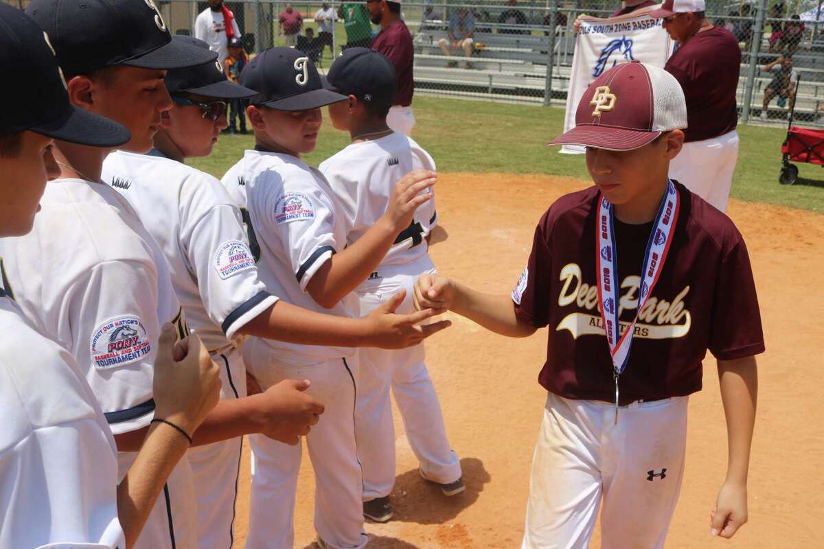 Deer Park's Aidan Weed walks down the line of Tamiami players after he received his medal from Pony Baseball officials, following Sunday's South Zone title game. The Miami team is headed to the World Series after their 11-7 win.
