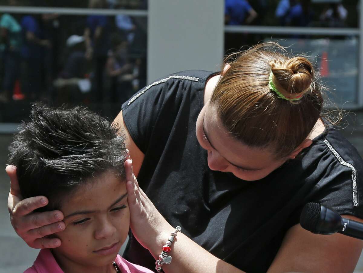 Honduran immigrant Dalila Hernandez comforts her son Jonathan, 8, before meeting with the media. Catholic Charities is one of four U.S. cities designated to assist the federal government in reuniting upwards of 3,000 Central American families that were forcibly separated at the border by its "zero-tolerance" policy. The non-profit organization has set up a "command center" on the second floor to greet families and help get them to their designations across the country.