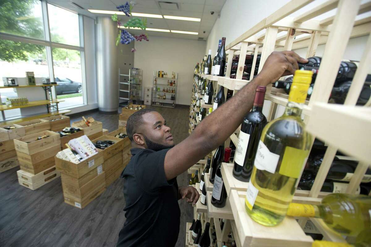 Employee James Bethea adds a bottle of wine to a shelf inside the new Harbor Point Wines & Spirits at 130 Washington Blvd., in the South End of Stamford, Conn., on Monday, July 16, 2018.