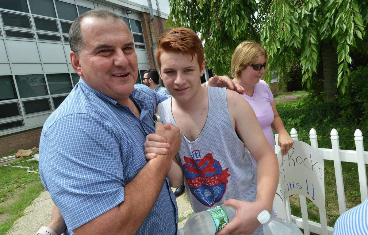 West Rocks Middle School Vice Principal Joe Devellis greets supporters like former student Luca Piacenza as he enters the school on Monday July 23, 2018 in Norwalk Conn. to discuss where he will be assigned for the new year with Frank Costanzo, Chief of School Operations for Norwalk Public Schools and Anthony Shannon, Director of Labor Relations for Norwalk Public Schools
