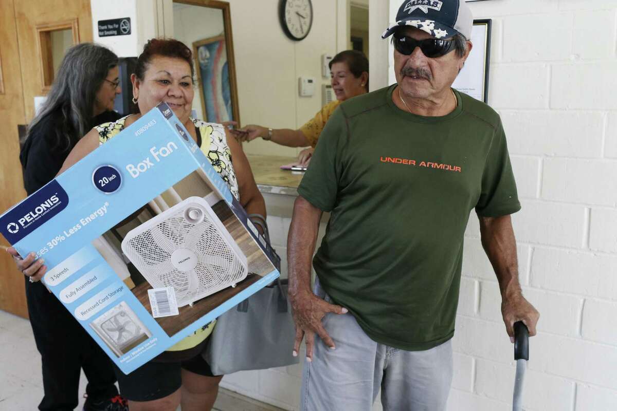 Gricelda and Amando Pozada pick up a fan at the Guadalupe Community Center. The center hands out donated fans and is asking the public for donations to keep up with the demand.