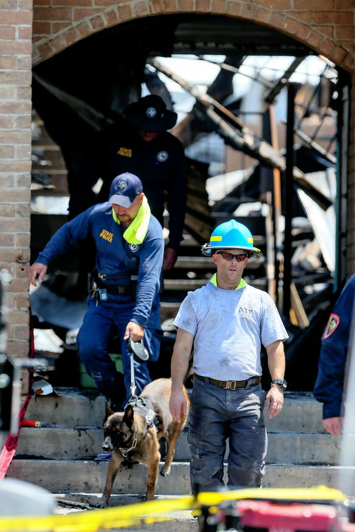 Investigators walk through an entryway at the Iconic Village Apartments in San Marcos on Monday, July 23, 2018. Four victims have been recovered so far from the fire that began at the apartment complex at 4:30 a.m. and affected three apartment buildings on Friday, July, 20. Five people are still unaccounted for. Officials do not yet know the origin of the fire, how it started. or what the total number of victims will be.