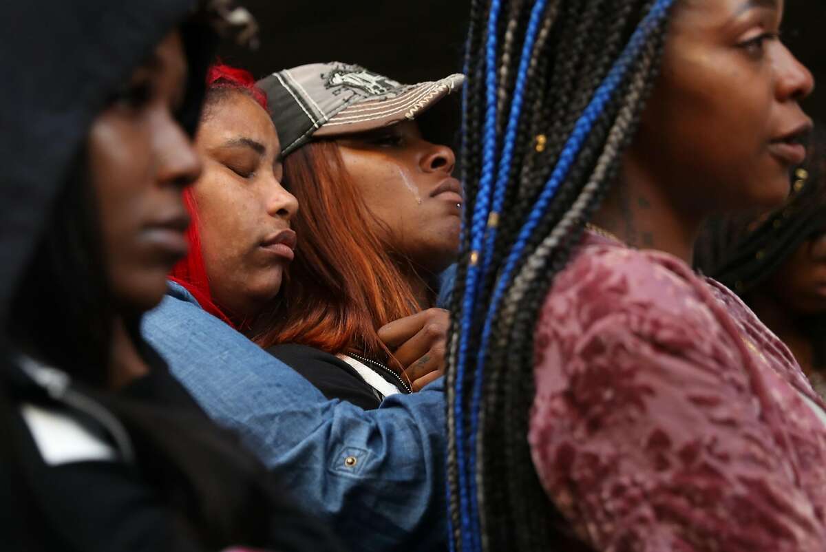 Friends of Nia Wilson mourn during a vigil in memory of the 18-year-old stabbing victim at McArthur BART Station in Oakland, Calif. on Monday, July 23, 2018.