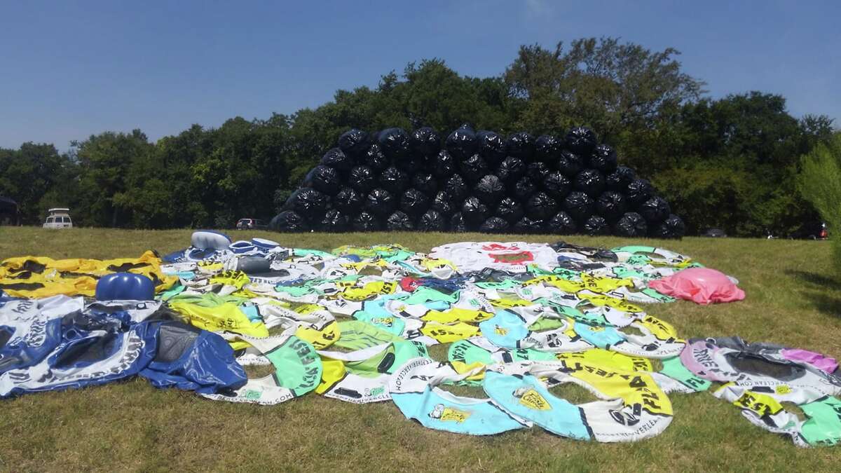 A cleaning crew collected 40,000 beer cans, 800 pounds of flat tubes, nearly 200 pounds of recyclable plastics, and several bags of clothes and shoes during Float Fest. Some crew members were paid by Float Fest and others were volunteering with The Eyes of the San Marcos River. Shown here is one of three group's hauls for one day of the festival. (Courtesy of Zach Halfin)