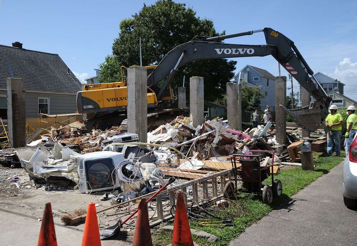 A home at 24 Cooper Avenue in Milford, Conn is demolished on Tuesday, July 24, 2018 after it collapsed while being raised on to new concrete pilings on Monday.