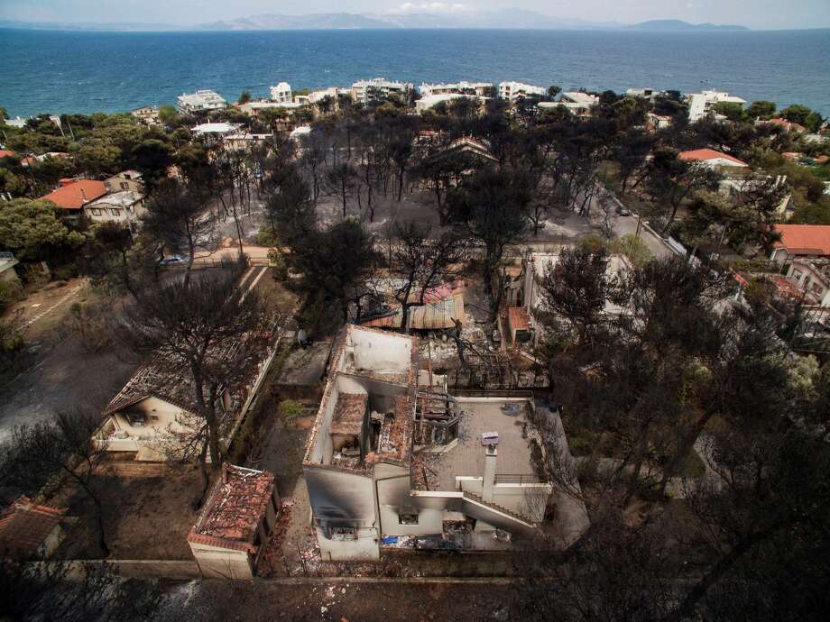 An aerial view shows burnt houses following a wildfire in the village of Mati, near Athens, on July 24, 2018. - Raging wildfires killed 60 people in Greece, devouring homes and forests as terrified residents fled to the sea to escape the flames, authorities said on July 24, 2018. Orange flames engulfed pine forests, turning them to ash and leaving lines of charred cars in the smoke-filled streets of seaside towns near Athens. Photo: SAVVAS KARMANIOLAS/AFP/Getty Images / This content is subject to copyright.
