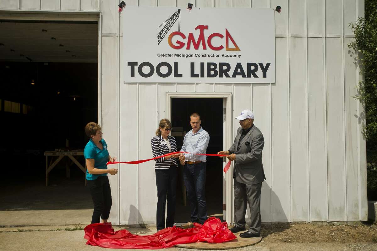 From left, Stephanie Davis, vice president of the Greater Michigan Construction Academy, Sharon Mortensen, president of the Midland Area Community Foundation, Jeff Havens and Jimmy Greene, CEO of the GMCA, cut a ribbon during an event celebrating GMCA's new tool library on Tuesday, July 24, 2018 in Midland. (Katy Kildee/kkildee@mdn.net)