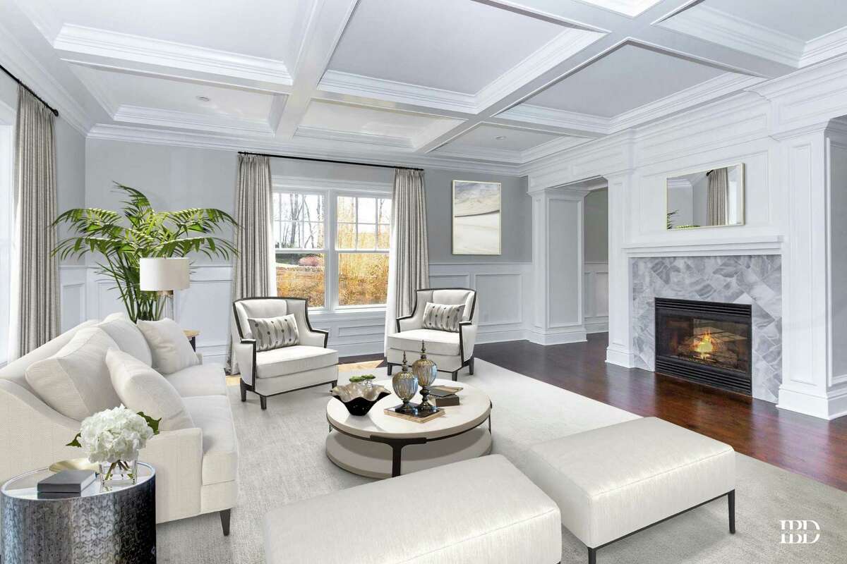 In the formal living room there is a coffered ceiling, wainscoting on the lower walls, and a two-sided fireplace with a marble surround. (*This photo is virtually staged)
