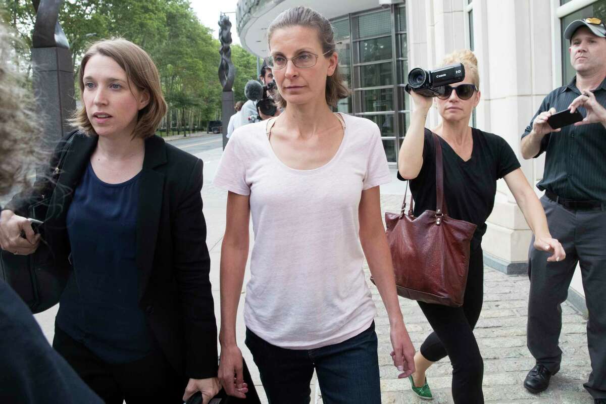Clare Bronfman, center, leaves federal court, Tuesday, July 24, 2018, in the Brooklyn borough of New York. Bronfman, an heiress to the Seagram's liquor fortune and three other people were arrested on Tuesday in connection with the investigation of a self-improvement organization accused of branding some of its female followers and forcing them into unwanted sex.