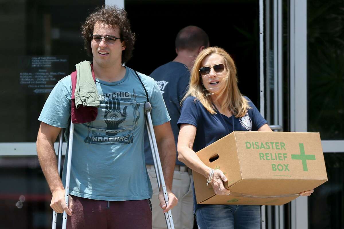 A county volunteer (right) helps Jackson King, 22, a senior at Texas State University, to his car with a disaster relief box at the San Marcos Activity Center on Tuesday, July 24, 2018. King lived on the first floor of building 500 at the Iconic Village Apartments that was destroyed by the fire the previous Friday. The City of San Marcos, along with the Red Cross, Salvation Army and the Central Texas Food Bank provided food boxes (enough food for one week), toiletries, counseling services, gift cards, lunch and assistance on housing to victims of the fire at the Activity Center from 10:00 a.m. to 7:00 p.m. today and tomorrow.