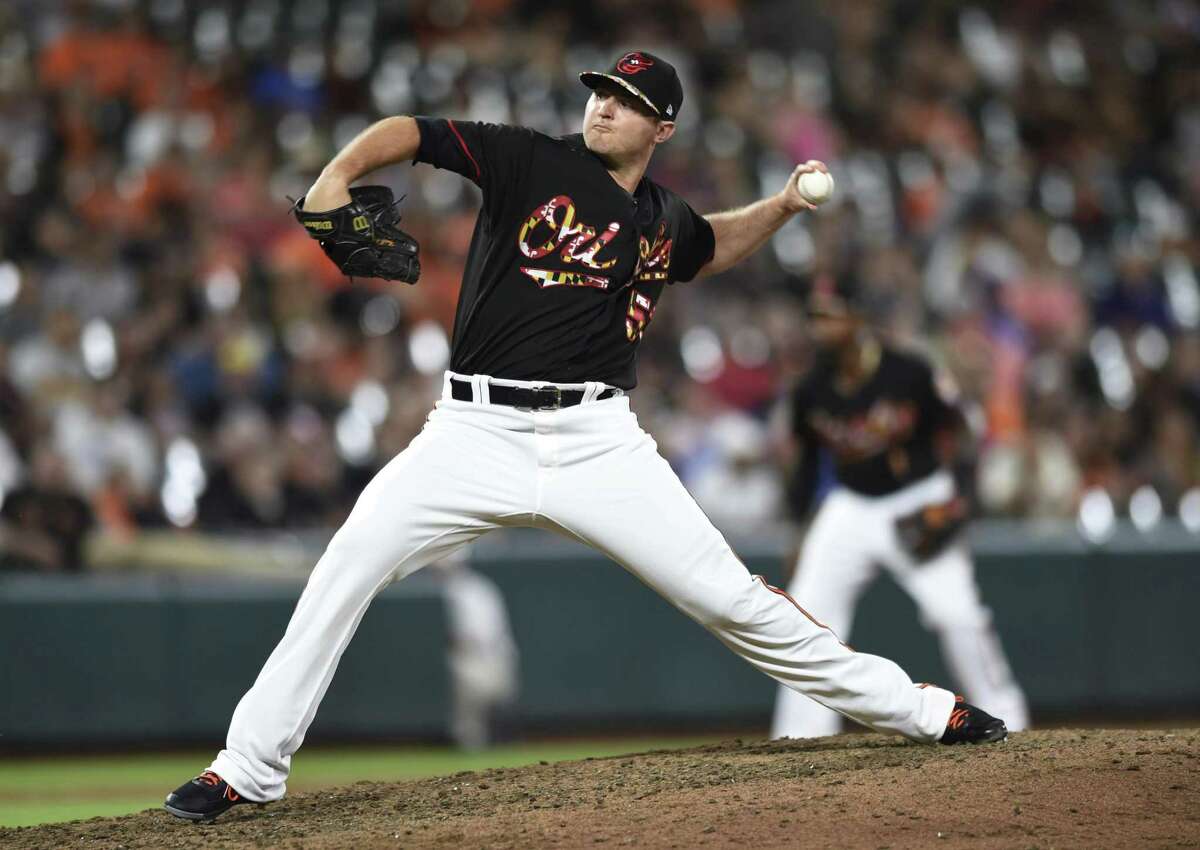 FILE - In this July 14, 2018, file photo, Baltimore Orioles' Zach Britton throws to a Texas Rangers batter during the ninth inning of a baseball game in Baltimore. A person familiar with the talks tells The Associated Press the New York Yankees are close to agreement on a trade to acquire Britton from the rebuilding Orioles for three prospects, a deal that would bolster New York's bullpen for the stretch run. (AP Photo/Gail Burton, File)