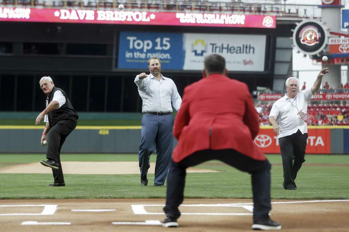 Cincinnati Reds Hall of Fame inductees, from back left to right, Dave Bristol, Adam Dunn and Fred Norman, throw out ceremonial first pitches during their induction ceremony before a baseball game against the Pittsburgh Pirates, Saturday, July 21, 2018, in Cincinnati.