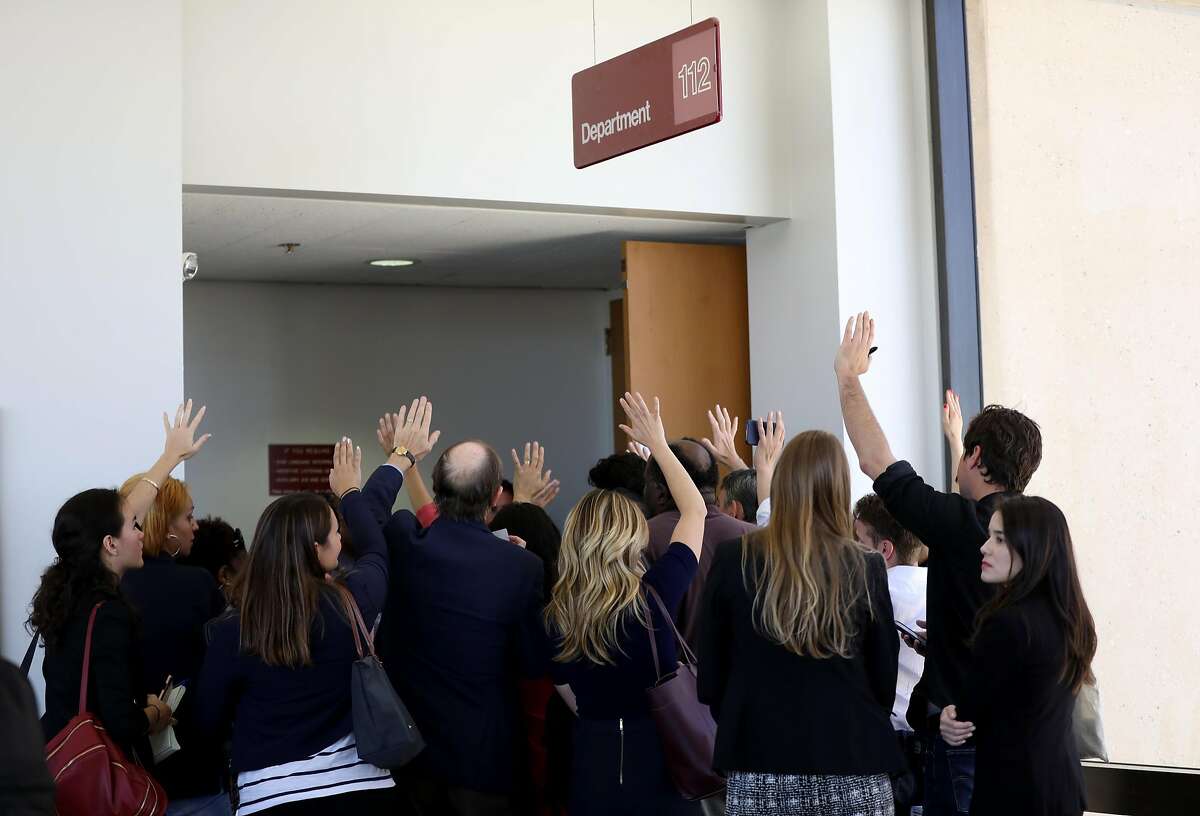 Members of the media raise their hands as they vie to grab one of the few seats available inside a courtroom to witness the arraignment of John Lee Cowell at Wiley W. Manuel Courthouse in Oakland, Cali. on Wednesday, July 25, 2018. Cowell, 27, is accused of a double stabbing, which killed Nia Wilson, 18, and injured her older sister, Lahtifa Wilson, 26, at the MacArthur BART station on Sunday evening.