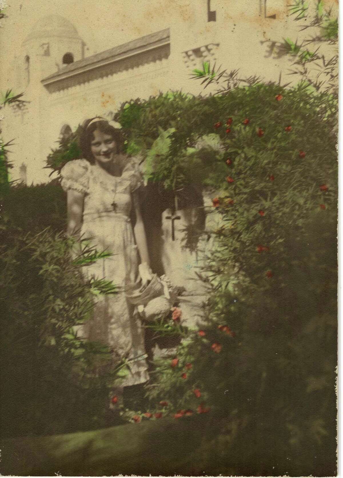Aline B. Carter in her backyard with the Municipal Auditorium in the background in the early 1930s.