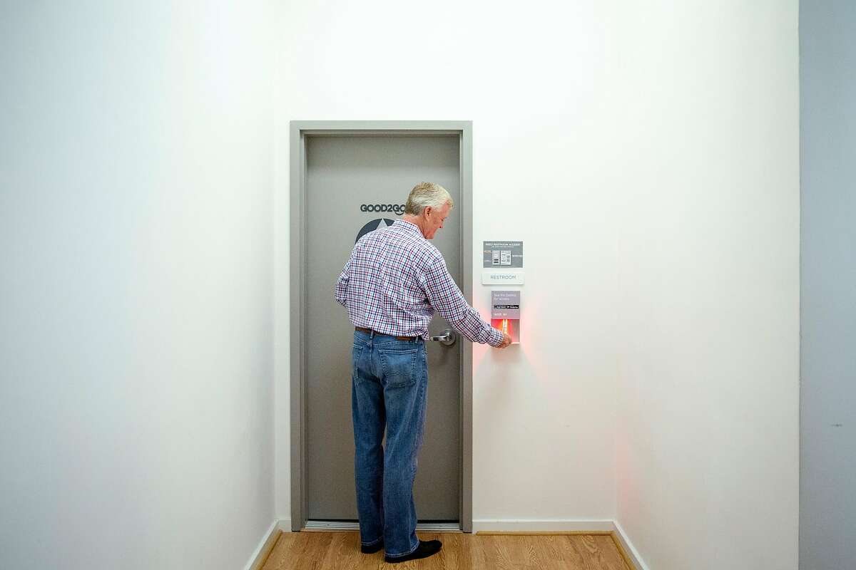 The Creamery's Ivor Bradley scans a barcode that automatically opens the door to the restroom after he was notified by an electronic display that he is next in line during a training session at the Good2Go headquarters, Thursday, July 26, 2018, in San Francisco, Calif. Good2Go is an app that grants users access to restrooms.