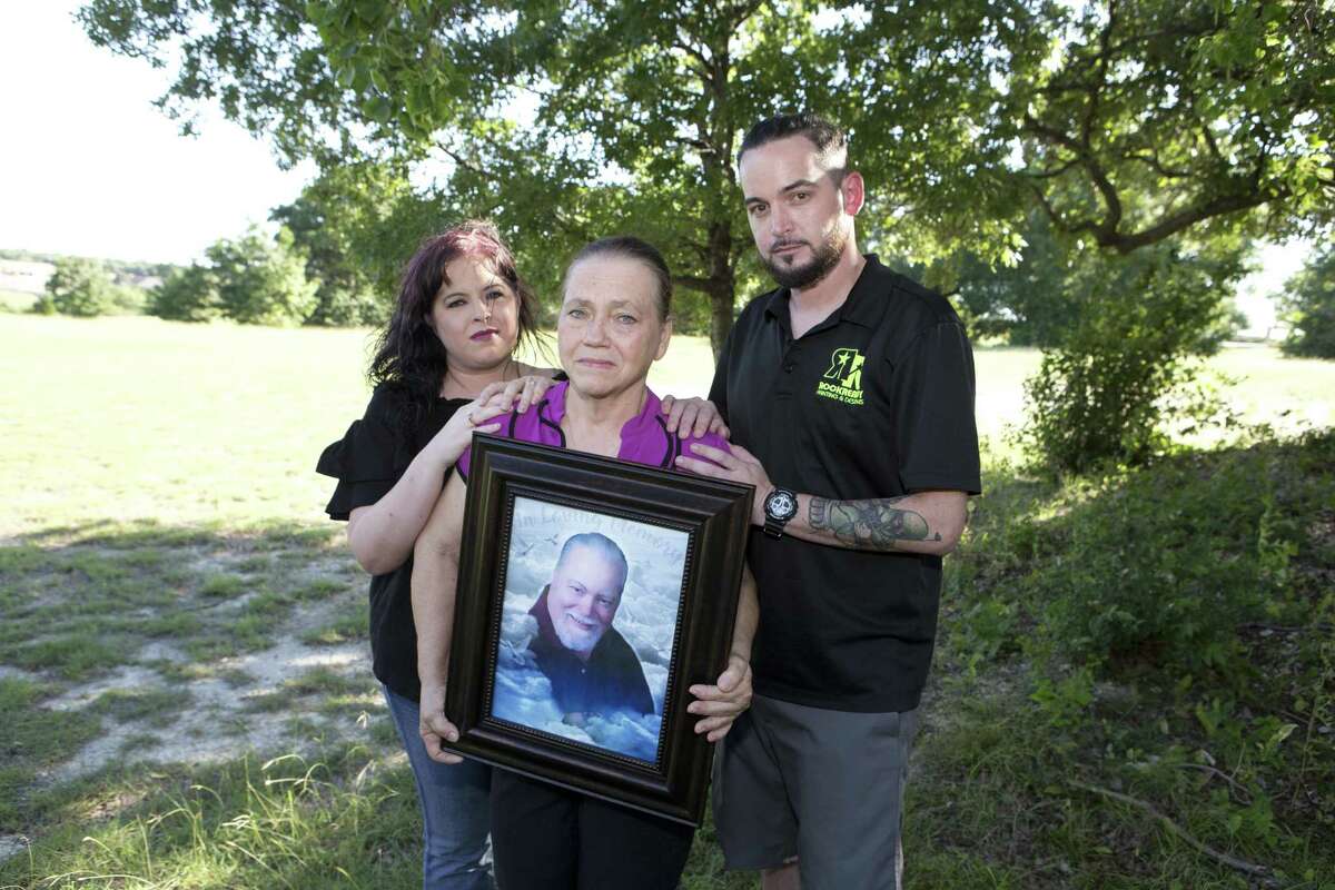 Sandra McCollum ( center) holds a portrait of her late husband, Larry Gene McCollum, who died of heatstroke in 2011 while incarcerated at a state prison.