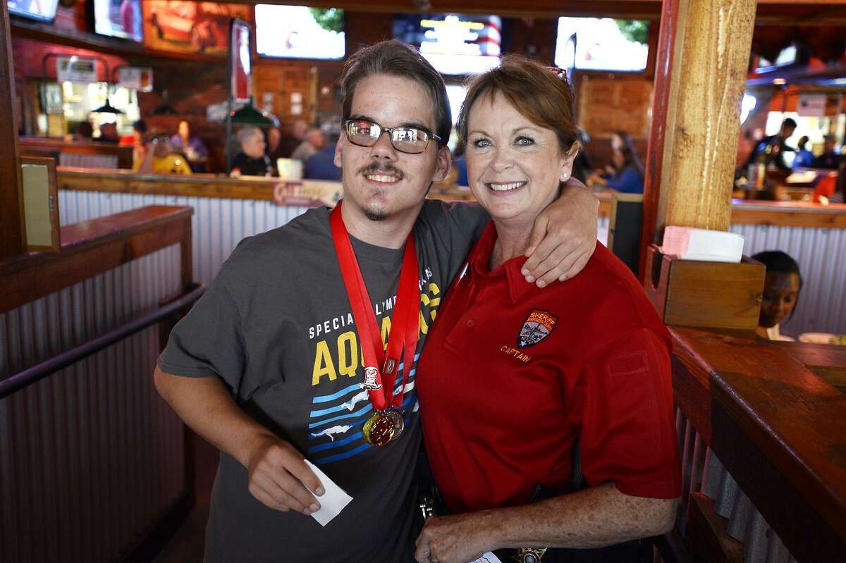 Jefferson County Sheriff's Captain Crystal Holmes and athlete Jayden Jones during the "Tip A Cop" fundraiser for Special Olympics Texas at Texas Roadhouse. Money raised at the event stays in the local area to help by equipment and pay for competitions for athletes. Photo taken Thursday 7/26/18 Ryan Pelham/The Enterprise