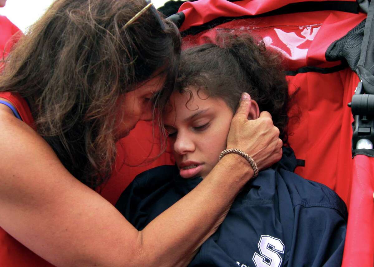 Sami Leskin, of Westport, gets a quick embrace from her mom Lori as Sami with myTEAM TRIUMPH gets ready to take part in the Fairfield Police Department Sunset 5K at Penfield Beach in Fairfield, Conn., on Wednesday, July 25, 2018. myTEAM TRIUMPH is a new organization where volunteers pair with clients of the Norwalk nonprofit STAR to help people with disabilities be able to participate in races using specialized racing wheelchairs.