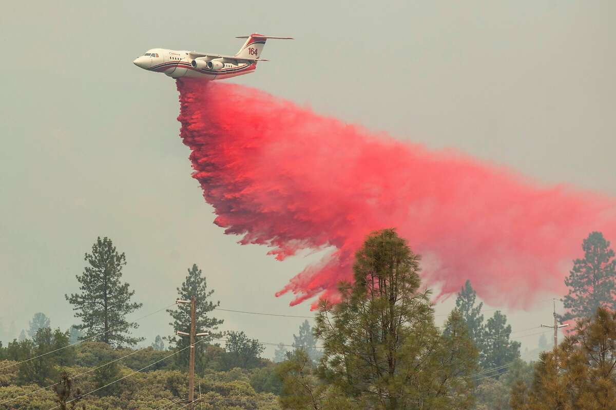 A fire retardant bomber drops it's payload on the Carr Fire as it burns out of control away from downtown Redding, Friday 27 July 2018 in Shasta, CA.