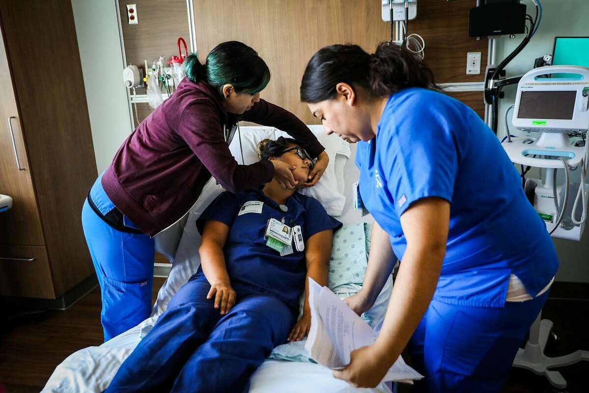 (l-r) Sara Salazar turns Ana Diaz's head while Melina Paniagua looks on during an emergency simulation at the new Sutter-owned CPMC hospital in San Francisco, California, on Wednesday, July 25, 2018.