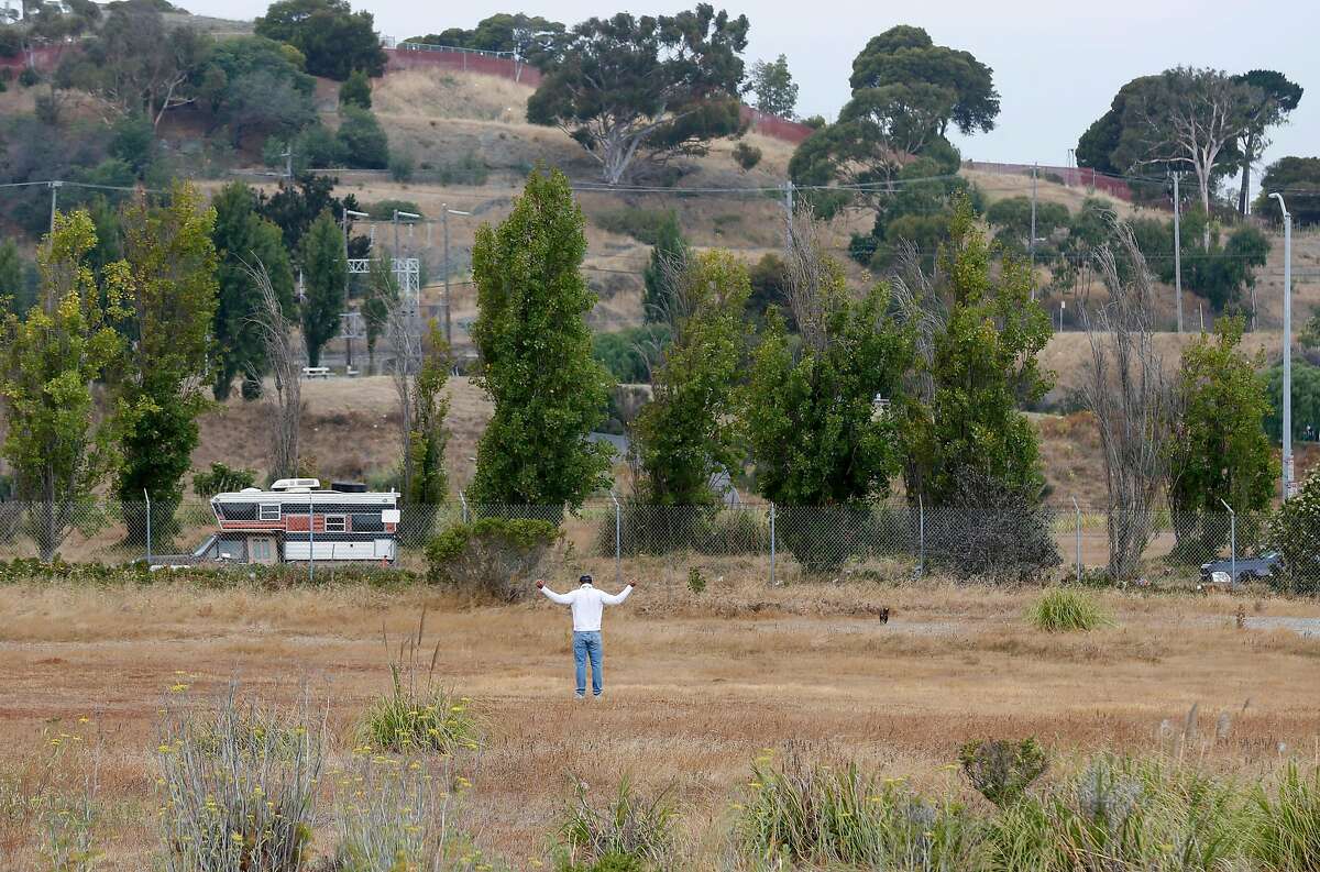A man stretches in a vacant parcel of land at India Basin in San Francisco, Calif. on Wednesday, July 18, 2018. A developer is seeking approval to construct more than 1,500 homes on the site off of Innes Avenue and Arelious Walker Drive.