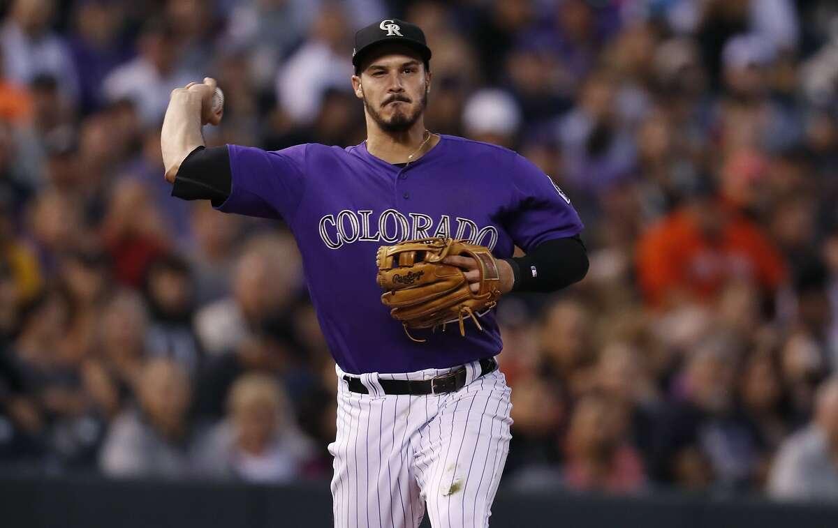 In this Wednesday, July 25, 2018, photo, Colorado Rockies third baseman Nolan Arenado throws to first base to put out Houston Astros' Yuli Gurriel in the sixth inning of a baseball game in Denver. The Rockies All-Star received a brief taste of success last season when the team made it to the postseason as an NL wild-card. (AP Photo/David Zalubowski)