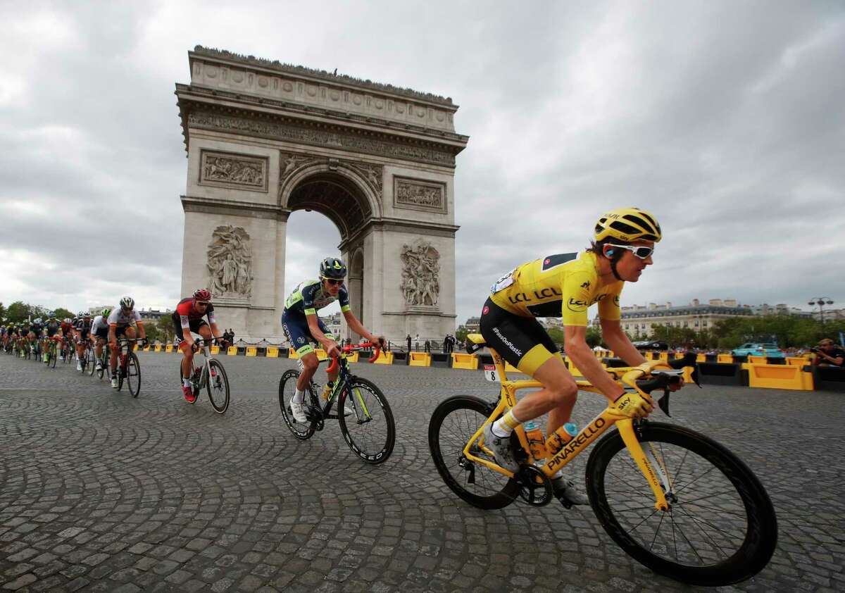 Tour de France winner Britain's Geraint Thomas, wearing the overall leader's yellow jersey, passes the Arc de Triomphe during the twenty-first stage of the Tour de France cycling race over 116 kilometers (72.1 miles) with start in Houilles and finish on Champs-Elysees avenue in Paris, France, Sunday July 29, 2018.