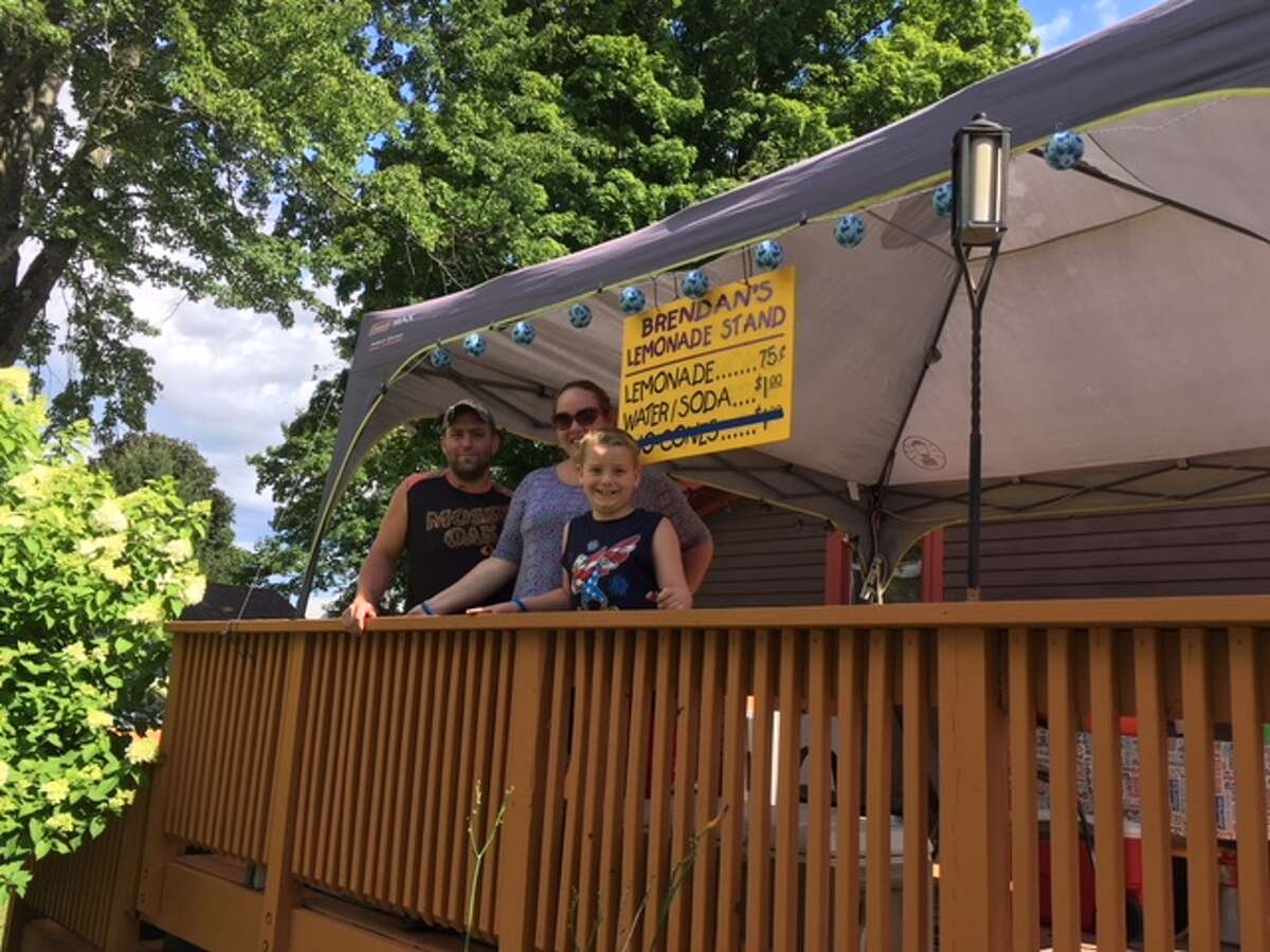 From left, Sean, Jodi and Brendan Mulvaney stand on the deck of their home where 7-year-old Brendan's lemonade stand was shut down by a woman who appeared to be with the state Department of Health on Friday, July 27, in Ballston Spa.