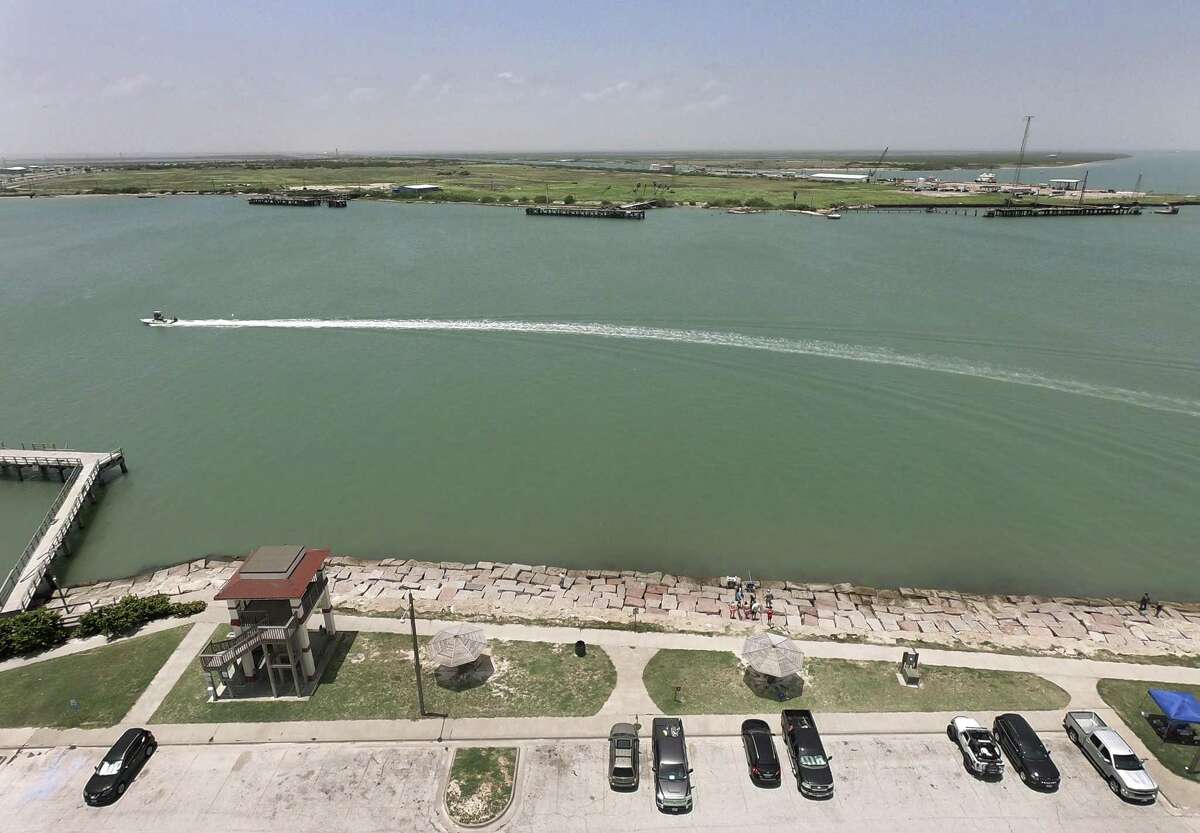 A boat traverses the waters between Port Aransas, foreground, and Harbor Island, in the distance. Harbor Island is the site of a 250-acre crude oil terminal proposed by the Port of Corpus Christi. It was once the site of an Exxon terminal.
