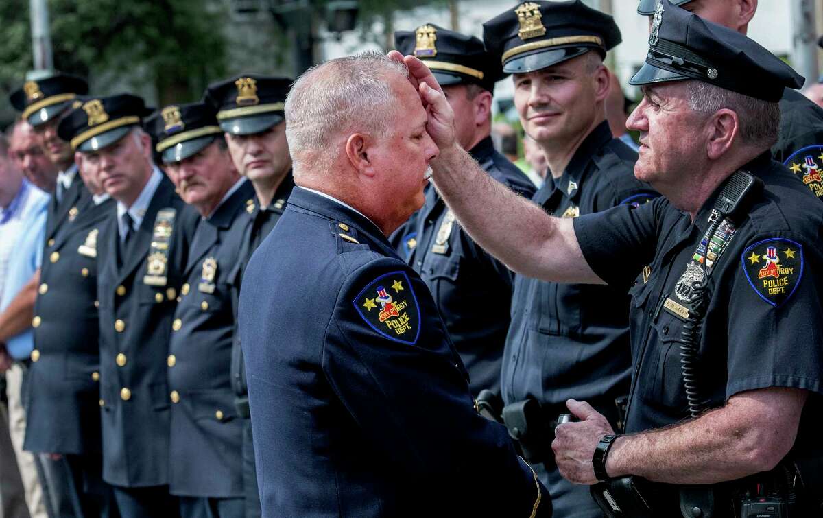 Captain Rick Sprague receives a blessing from lay priest Paul Carney after his retirement ceremony Monday July 30, 2018 in Troy, N.Y. Sprague was a 40 veteran of the Troy Police and commanded the Detective Division and the Emergency Response Team. (Skip Dickstein/Times Union)