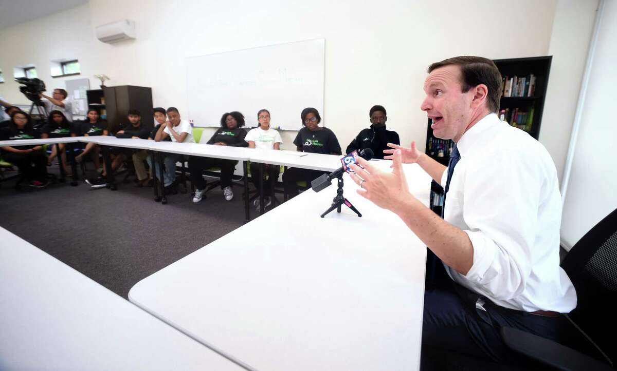 U.S. Sen. Chris Murphy, right, speaks with teens in the Squash Haven program in New Haven about gun violence Monday.