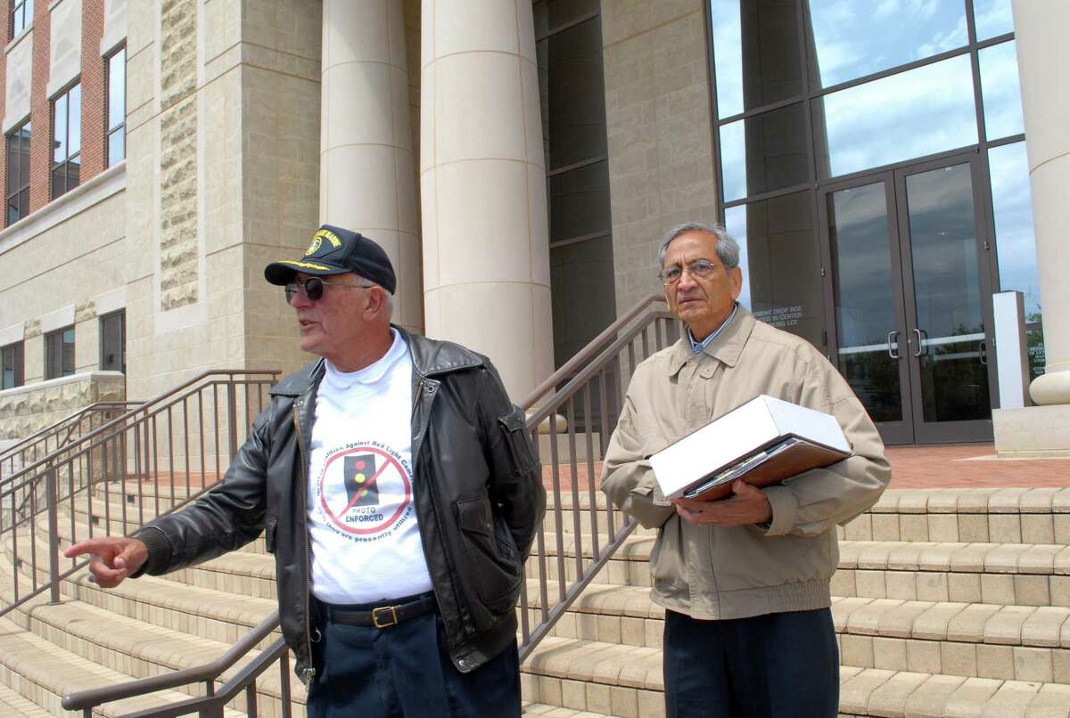 Hewing F. Van Der Grinten, left, and Ray Patel stand on the step of Sugar Land city hall during the 2013 press conference on the red light camera enforcement program.