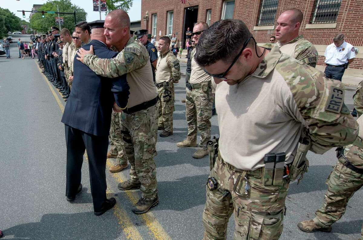 Captain Rick Sprague hugs one the members of the Emergency Response Team that he commanded outside the Troy Police headquarters after the his retirement ceremony Monday July 30, 2018 in Troy, N.Y. Sprague was a 40 veteran of the Troy Police and commanded the Detective Division and the Emergency Response Team. (Skip Dickstein/Times Union)