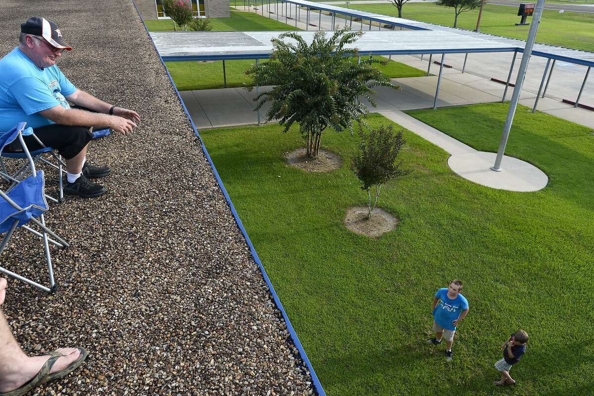 George Jordan, a fifth grade science teacher, talks with student Christian Gillikin and his brother, Cade, from the roof of Sour Lake Elementary School. Jordan has made it a tradition to spend a night on the school's roof if more than 90 percent of his students pass their STAAR test.