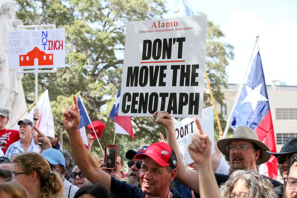 People display signs and flags during a rally opposing relocation of the Cenotaph in Alamo Plaza hosted by the Alamo Defenders Descendants Association on Saturday, July 28, 2018.