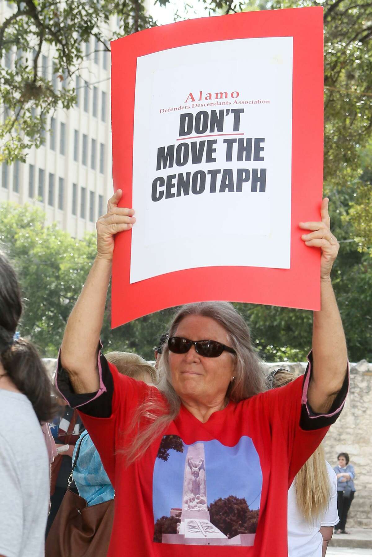 Sheila Kimple from Hayes County holds a sign reading "Don't Move the Cenotaph" during a rally opposing relocation of the Cenotaph in Alamo Plaza hosted by the Alamo Defenders Descendants Association on Saturday, July 28, 2018.
