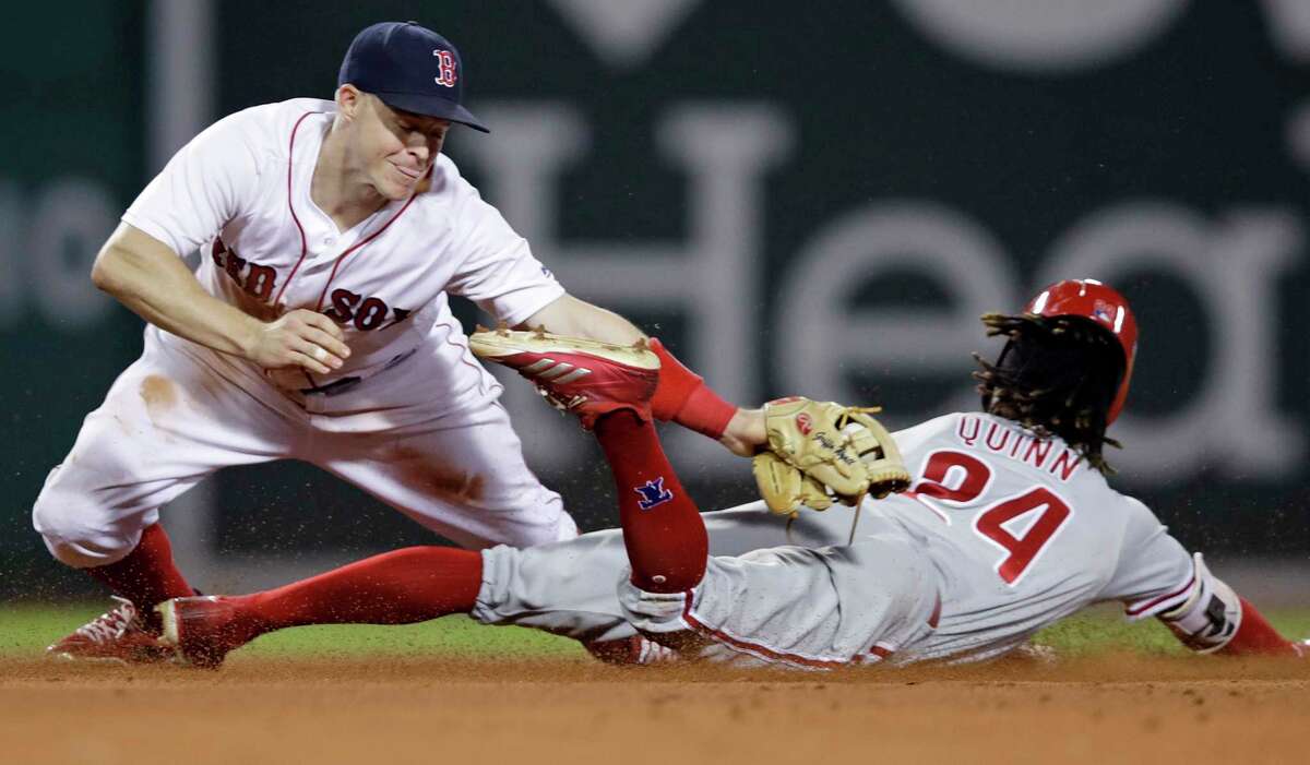 Boston Red Sox second baseman Brock Holt, left, tags out Philadelphia Phillies' Roman Quinn on a steal attempt during the ninth inning of a baseball game at Fenway Park in Boston, Monday, July 30, 2018. (AP Photo/Charles Krupa)
