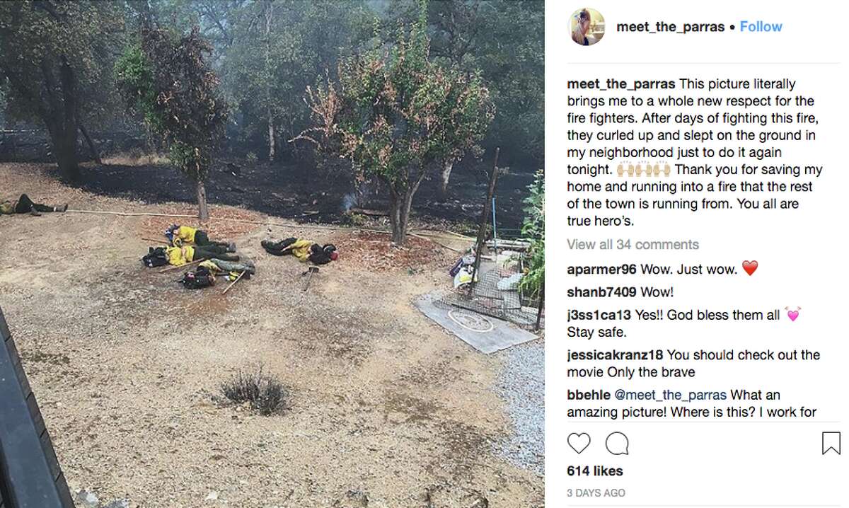 Firefighters sleep during a lull in a Redding neighborhood while fighting the Carr Fire.
