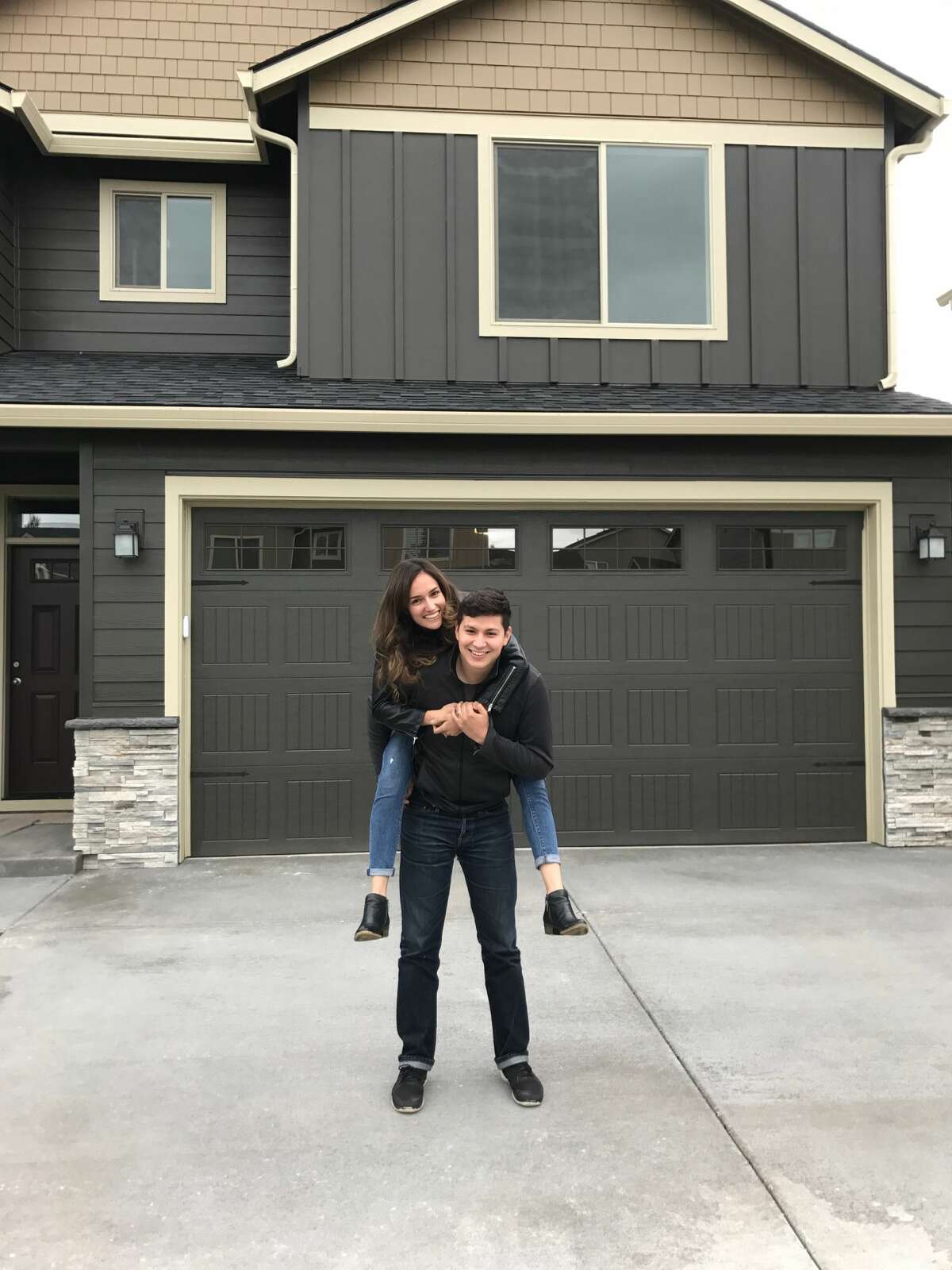 Nancy Fimbrez, 25, stands with her husband Stephen in front of the home they purchased in Vancouver, Wash., on the day they closed. "Usually people do not act surprised when we say we are from California," said Nancy. While the couple has seen some anti-Californian graffiti, most of the people they've met in the Pacific Northwest have been friendly.