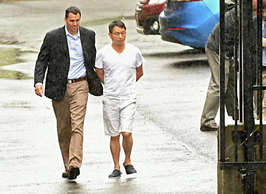 FBI agents escort General Electric engineer Xiaoqing Zheng to his arraignment at U.S. District Court in Albany on charges of theft of trade secrets. (Lori Van Buren/Times Union) Photo: Lori Van Buren, Albany Times Union / 20044466A