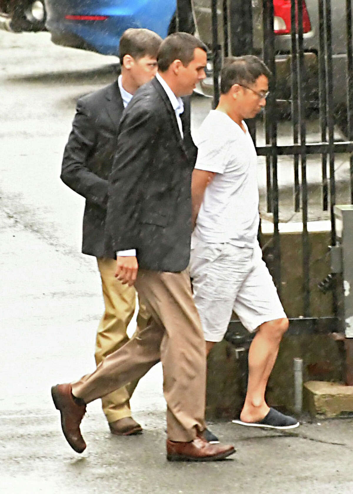 FBI agents escort General Electric engineer Xiaoqing Zheng to his arraignment at U.S. District Court in Albany on charges of theft of trade secrets.(Lori Van Buren/Times Union)